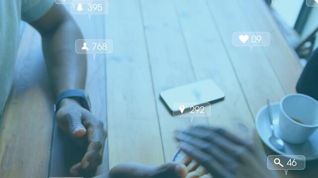 Notifications appearing and sparking couple clasping hands at cafe table, phone idle for marketing