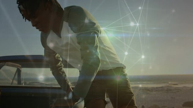 Man pulling truck to coast checking hood sitting watching sunset network overlay wrapping him tech