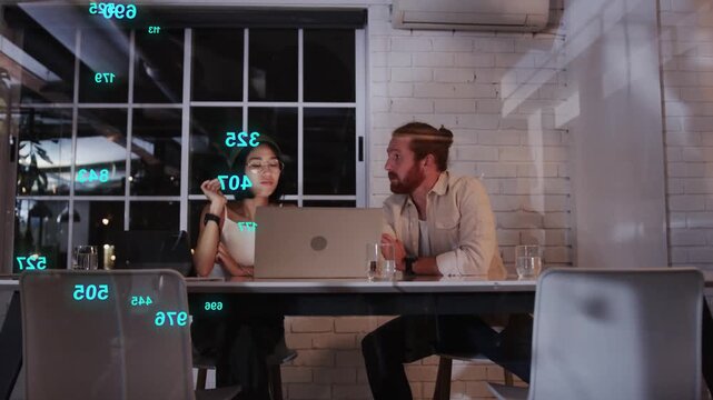 Woman typing on laptop, causing teal numbers then purple squares overlaying team reviewing business