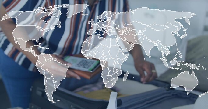 Packing senior woman striped blouse arranging suitcase on bed, phone showing QR, worldmap overlay