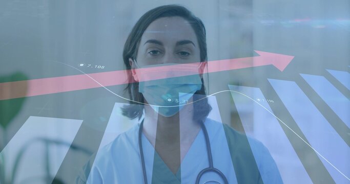 Standing clinician wearing light-blue scrubs surgical mask in clinic stethoscope pink arrow graph
