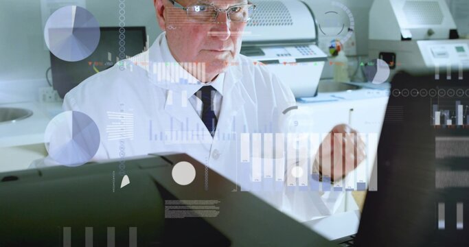 Viewing senior scientist reviewing monitors at lab bench, in lab coat, dark tie, glasses