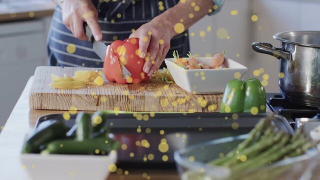 Cook placing red pepper at board, slicing to dice, prepping meal while yellow bokeh obscuring hands