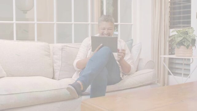 Man tapping tablet and testing tech app, smiling while soft light-leak overlay shifting across lap