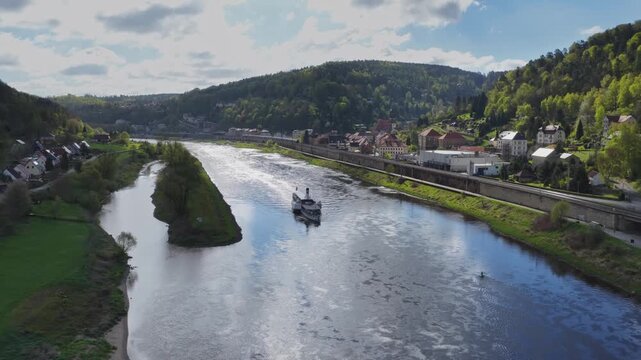 Aerial view of a historic paddle steamer cruising up the Elbe River through the picturesque Elbe Valley in Saxon Switzerland.