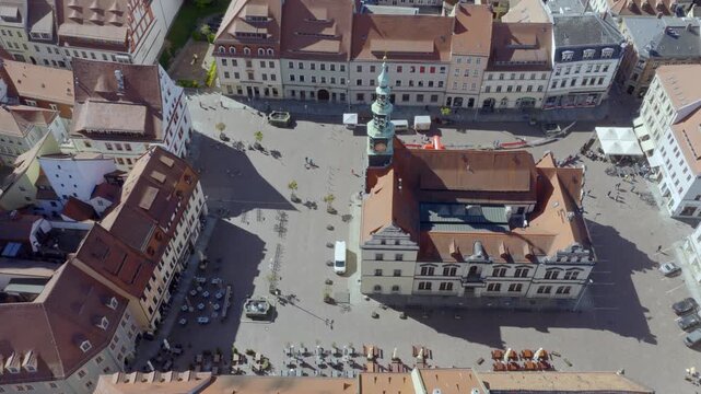 Aerial view of the historic market square in Pirna featuring the central town hall, surrounded by traditional townhouses and outdoor cafes.