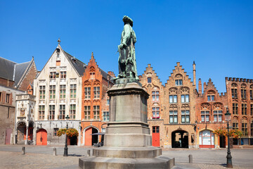 Obraz premium Jan van Eyck statue and medieval houses in Bruges, Belgium