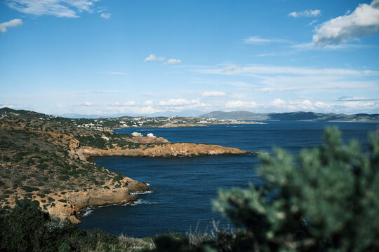Scenic Mediterranean coastline with white buildings and deep blue sea under a cloudy sky
