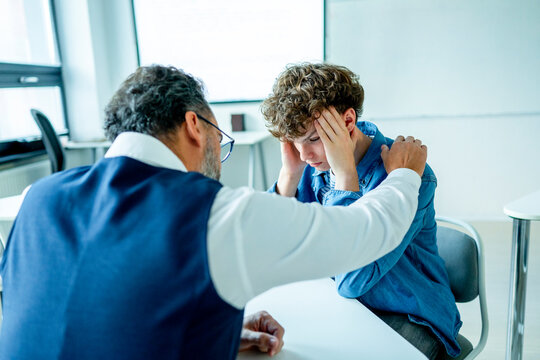 Teacher supporting struggling student. Boy confiding in a teacher.