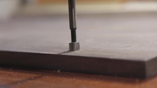 Tool drills hole into wood surface and guides the process of creating an opening for assembly