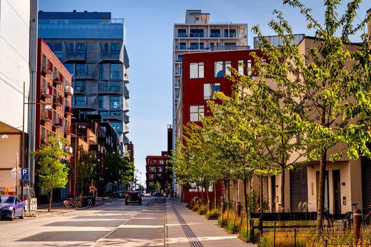 The modern green district of Nordhavn in Copenhagen with people running, cars, life on streets Denmark.