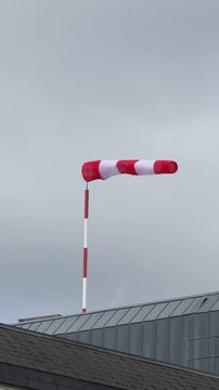 Rot-wei&szlig;er Windsack flattert in kräftigem Wind
