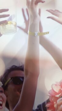 Vertical video: Woman raising arm while celebrating, group reaching for clear cup at music festival