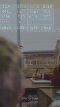 Vertical video: Female pupil writing in class to learn while camera panning revealing board charts