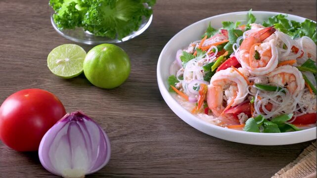 Spicy glass noodles with minced pork and shrimp on a wooden