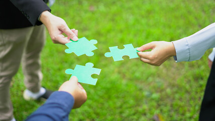 Fototapeta premium Teamwork Coworker's hand holding jigsaw puzzle With the cooperation of business people join together to campaign Environment concept, Copy space for your text.