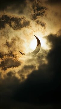 Cloudy sky with a small sun eclipse.