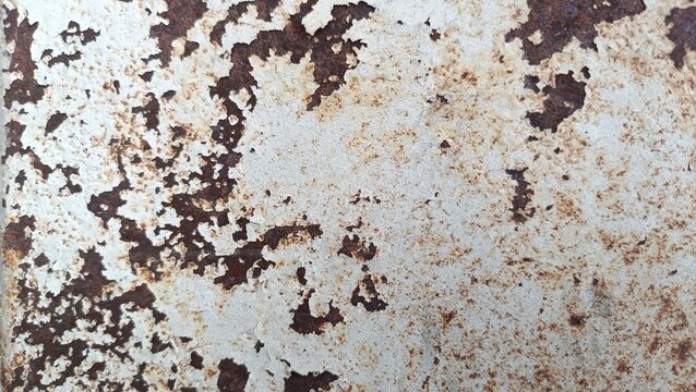 A close-up view of a weathered metal surface with rust and corrosion