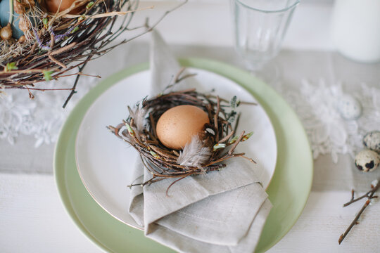 Close-up of an Easter place setting decorated with an egg in a bird's nest on a dining table