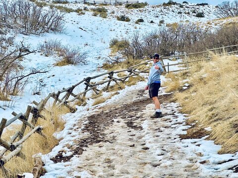 Happy man standing on a snowy and muddy path giving a thumbs up to camera, Ensign Peak Nature Trail, Salt Lake City, Utah, USA