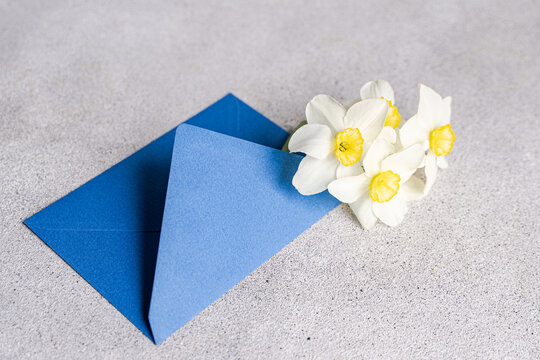Close-up of a bunch of daffodils in a blue envelope on a table