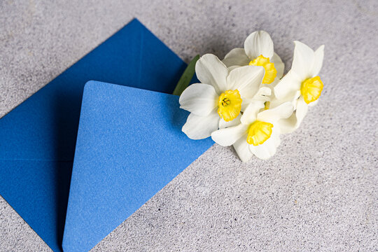 Close-up of a bunch of daffodils in a blue envelope on a table