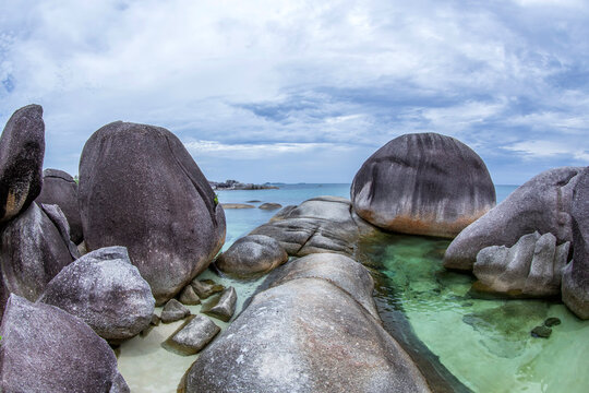 Large granite boulders on Tanjung Tinggi beach on an overcast day, Belitung Island, Indonesia