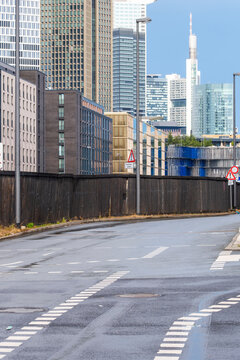 Empty Frankfurt street and road lead toward modern skyline towers in urban Germany with clean infrastructure lines and a restrained metropolitan atmosphere