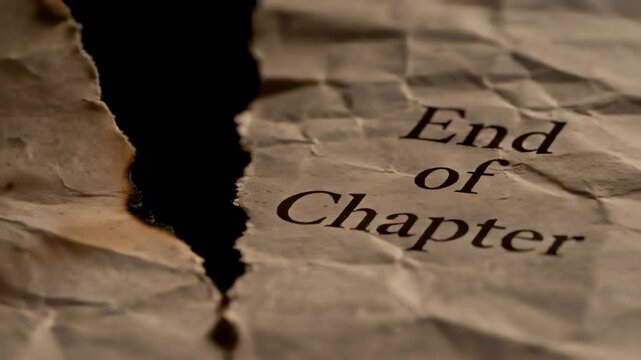 Applying lit matchstick to crumpled torn paper edge on tabletop, burning 'End of Chapter' margin