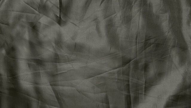 crumpled gray fabric texture closeup with intricate ribbed patterns shadowy folds and enigmatic depth in abstract minimalist composition