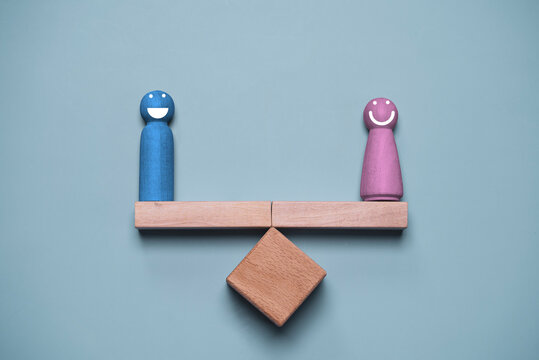 Gender equality concept with male and female figures balanced on a wooden scale, representing equal rights, fairness, diversity, inclusion, workplace equality, and social justice in modern society
