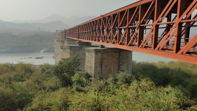Attock khurd bridge lower walkway showing railway track above with long vanishing perspective over indus river