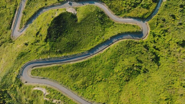 Narrow street climbing a green meadow mountain in Calabria