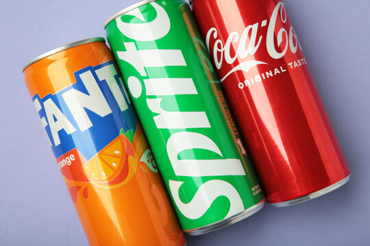 Mykolaiv, Ukraine - March 25, 2026: Iron cans of Coca Cola, Fanta and Sprite drink on purple background.