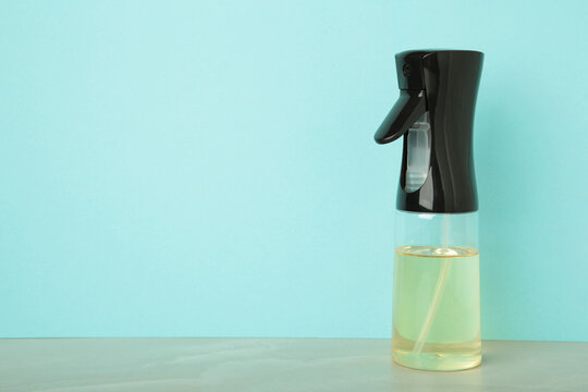 Cooking oil glass sprayer on blue background. Space for text