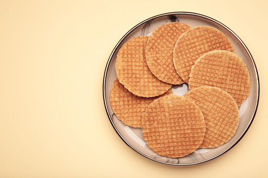 Dutch waffles stroopwafel syrup waffle caramel waffle on plate on beige background. Space for text
