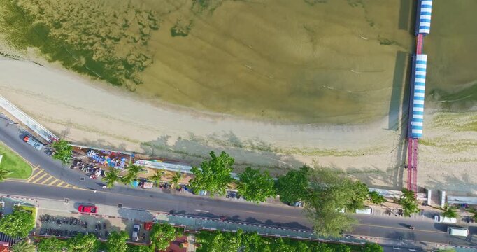 
Drone view of Patong Beach showing moss and algae covering sections of the sand while a tractor clears the shoreline. This scene captures the contrast between natural coastal growth 