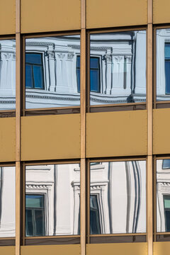Abstract modern building facade with warped windows and visible distortion creating a fluid geometry pattern as reflection bends across the surface