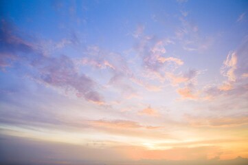Obraz premium Colorful sunset sky with pastel clouds, tranquil scene, natural beauty, serene atmosphere, vibrant hues, evening light, outdoor setting, scenic landscape, relaxing mood