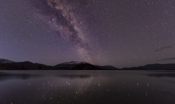 Night Scene, Wanaka lake with stars and Milky Way, stars mirroring in the water, Glendhu Bay, Otago, Southland, New Zealand