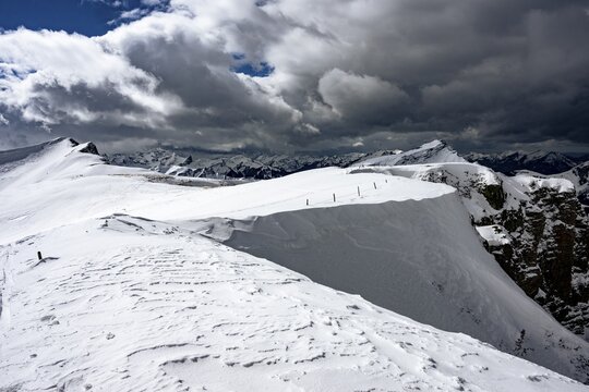 Berlinger K&ouml;pfl summit area with snow-covered mountains in the background and dramatic sky, Berlinger K&ouml;pfle, Ritzlern Kleinwalsertal, Vorarlberg, Austria