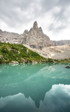 Turquoise green Sorapis lake, Lago di Sorapis with reflection and mountain top Dito di Dio, Dolomites, Belluno, Italy