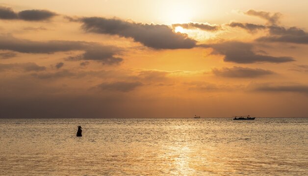 Sunset over the sea, fisherman standing in the water, backlit, Lovina Beach, Bali, Indonesia