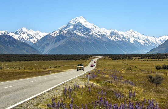 Campervan on country road overlooking snow-capped Mount Cook National Park, Southern Alps, Canterbury, South Island, New Zealand