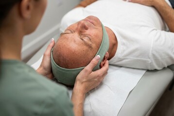 Fototapeta premium Man receiving head support lying on therapy table close-up