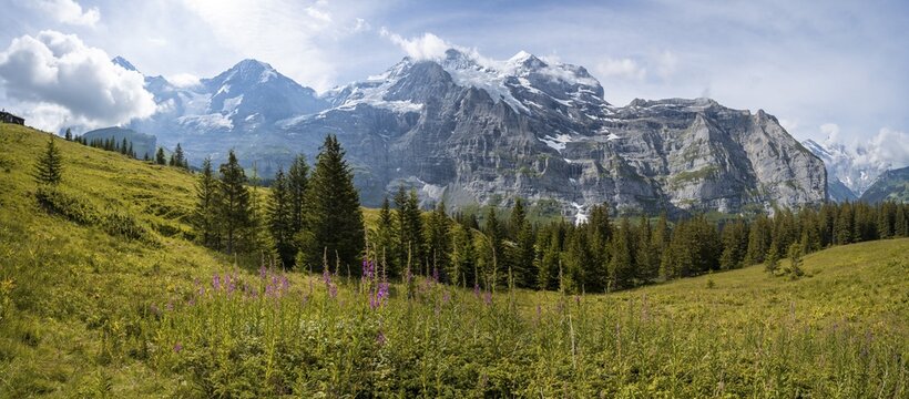 Two (hikers) on a hiking trail, in front of the Eiger north face, behind mountains and mountain tops, steep face and mountains, Jungfrau region, Lauterbrunnen, Bernese Alps, Switzerland