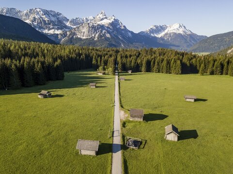 Hay barns in a meadow, Ehrwalder Sonnenspitz and mountains, near Ehrwald, Mieminger Kette, Tyrol, Austria