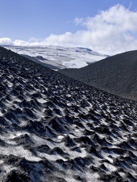 Ash-covered snowfield with the Eyjafjallaj&ouml;kull on the long-distance hiking trail from Sk&oacute;gar via Fimmv&ouml;r&eth;uhals to the Th&oacute;rsm&ouml;rk mountain ridge, &THORN;&oacute;rsm&ouml;rk, Iceland