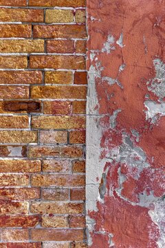 Old wall, brick wall next to red wall with crumbling paint, Venice, Italy