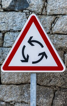 Triangular red and white road sign, roundabout